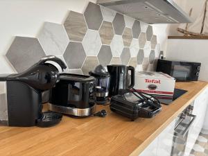 eine Küchentheke mit Kaffeemaschine und Kaffeekanne in der Unterkunft La Vallée des Biches G1 in Saint-Martin-Boulogne