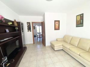 a living room with a couch and a television at Isca Calabretta Apartments M28 in Isca sullo Ionio