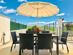 a table with chairs and an umbrella on a patio at Isca Calabretta Apartments M28 in Isca sullo Ionio