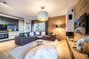 un salon avec un canapé et une table dans l'établissement Maira Les Carroz - by EMERALD STAY, à Arâches-la-Frasse