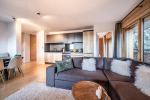 un salon avec un canapé marron et une table dans l'établissement Maira Les Carroz - by EMERALD STAY, à Arâches-la-Frasse