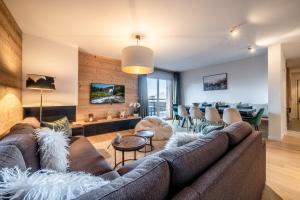 un salon avec un canapé et une table dans l'établissement Maira Les Carroz - by EMERALD STAY, à Arâches-la-Frasse
