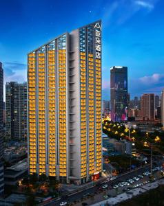 a lit up building in a city at night at Atour Hotel Kunming Changshui International Airport Cloud Cube in Kunming