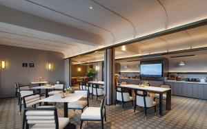 a restaurant with tables and chairs and a kitchen at Atour Hotel Kunming Changshui International Airport Cloud Cube in Kunming