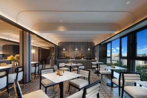 a restaurant with tables and chairs and a bar at Atour Hotel Kunming Changshui International Airport Cloud Cube in Kunming
