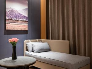 a living room with a couch and a table at Atour Hotel Kunming Changshui International Airport Cloud Cube in Kunming