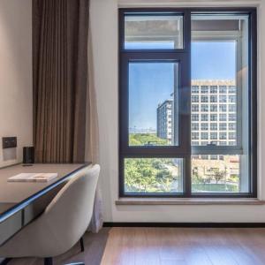 a room with a desk and a large window at Atour Hotel Beijing Shangdi Industrial Park Xierqi Subway Station in Beijing