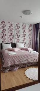 a bedroom with a bed with a pink comforter at Pensiunea Casiana in Ciulpăz