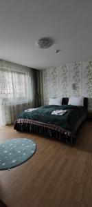 a bedroom with a large bed with a green blanket at Pensiunea Casiana in Ciulpăz