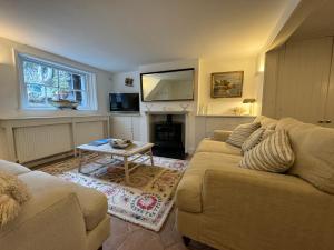 a living room with a couch and a fireplace at Picturesque Seaside Cottage Next to Viking Bay - Broadstairs in Broadstairs