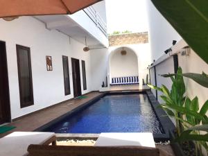 a swimming pool in the courtyard of a house at Double D Guesthouse and Villa in Kerobokan