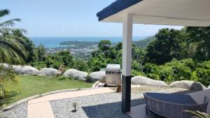 a patio with a grill and a table and chairs at Villa Olympus Sea View Private Pool 4BR Near Kata Beach in Kata Beach