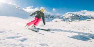 a man is skiing down a snow covered mountain at Hotel Acebo Plaza Mayor in Jaca