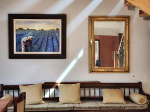 un espejo en una pared junto a un banco con almohadas en Verloren Lodge, en Modimolle