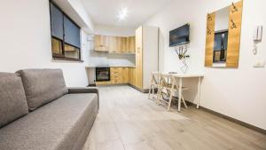ein Wohnzimmer mit Sofa und Tisch in der Unterkunft Panoramic de lux Mihai Bravu cu internet de mare viteza si parcare gratuit in Bukarest