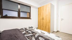 ein Schlafzimmer mit einem Bett und einem Fenster in der Unterkunft Panoramic de lux Mihai Bravu cu internet de mare viteza si parcare gratuit in Bukarest