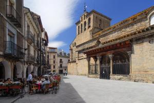 a group of people sitting at tables outside a building at Hotel Acebo Plaza Mayor in Jaca