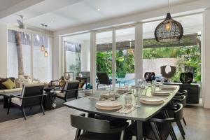 a dining room and living room with a table and chairs at Villa Levi by GORO in Seminyak