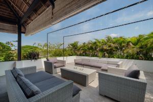 a patio with couches and a table and chairs at Villa Levi by GORO in Seminyak