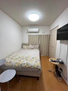 东京京成曳舟駅徒歩3分 寶島 2階 全1室的一间带床和桌子的小卧室