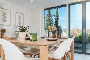 a dining room with a wooden table and white chairs at Luxuriöse Maisonette Oase mit Panoramablick in Stuttgart +21 photos