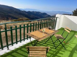 a table and chairs on a balcony with a view at The Snow Chalet con Parking, Wifi y Terraza in Sierra Nevada