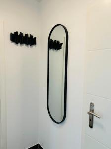 a mirror hanging on a wall next to a sink at Duvenstedter Rotklinker in Hamburg