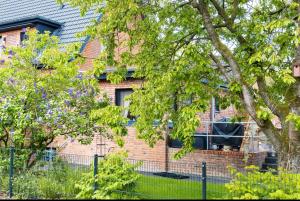 a brick house with a fence in front of it at Duvenstedter Rotklinker in Hamburg