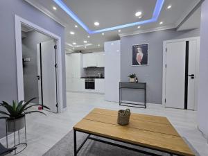 a living room with a table and a kitchen at Cozy Apartment - 5th Floor in Chişinău