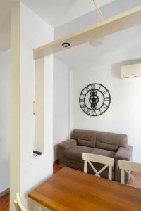 a living room with a couch and a clock on the wall at Sognando Vacanze Romane in Rome