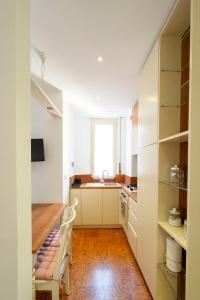 a kitchen with white cabinets and a wooden table at Sognando Vacanze Romane in Rome