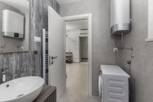 a bathroom with a sink and a toilet and a mirror at Apartments White and Green in Malinska +22 photos