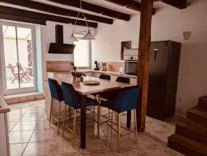 a kitchen with a wooden table and blue chairs at La Mariefacture comme un charme in Haute-Vigneulles +14 photos