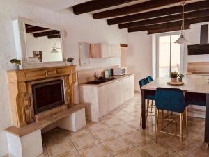 a kitchen with a table and a television and a dining room at La Mariefacture comme un charme in Haute-Vigneulles