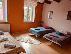 a room with three beds and two windows at La Mariefacture comme un charme in Haute-Vigneulles