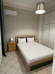 ピレウスにあるNikea apartment near Pireus port and metro st IIIのベッドとランプ付きのナイトスタンドのある寝室