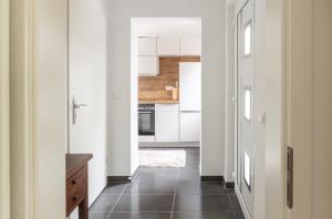 a kitchen with white cabinets and a black tile floor at Duvenstedter Rotklinker in Hamburg +3 photos