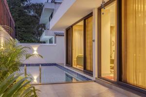 an external view of a swimming pool in a house at Casa Solace 3 BHK by tisyastays in Assagao