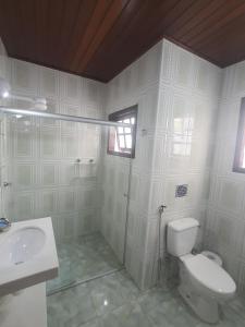 un bagno bianco con un water e un lavandino di Suítes Quintal de Lázaro 1 a Ubatuba Altre 13 foto