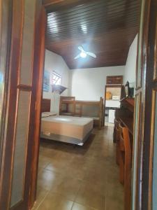 una camera da letto con un letto e un ventilatore a soffitto di Suítes Quintal de Lázaro 1 a Ubatuba