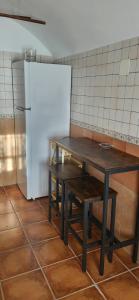a table in a kitchen next to a refrigerator at Alojamiento La tinaja in Guadix