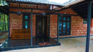 a house with a red brick wall with a black door at Prakruthi Home stay in Kanjikode +5 photos
