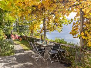 een patio met een tafel en stoelen onder een boom bij Apartment Egner- Apt-Steintisch by Interhome in Muralto