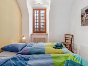 een slaapkamer met een bed met een kleurrijke deken bij Apartment Egner- Apt-Steintisch by Interhome in Muralto