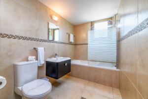 a bathroom with a toilet and a tub and a sink at Kymma Villa #12 in Ayia Napa +10 photos