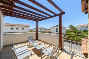 a patio with a table and chairs on a balcony at Kymma Villa #12 in Ayia Napa