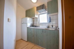una cucina con mobili verdi e un frigorifero bianco di Ferienwohnung in Luka mit Meerblick, Terrasse, Klimaanlage, W-LAN 4659-2 a Luka