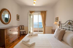 a bedroom with a bed with a mirror and a window at Villa Anastasia in Corfu +44 photos