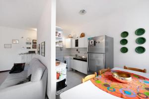 a kitchen and living room with a table and a refrigerator at Casa Laura in Arenzano +7 photos