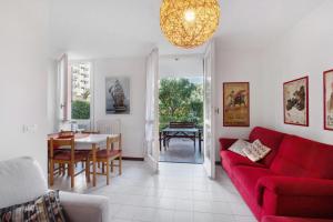a living room with a red couch and a table at Casa Laura in Arenzano